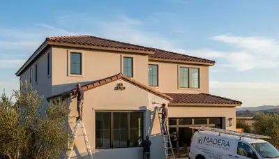 Professional house painters in Fresno CA applying exterior paint to a residential home façade